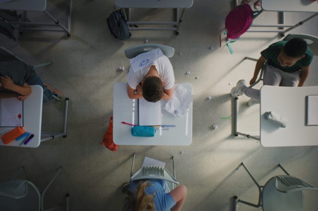 Sad,Elementary,School,Student,Sitting,Alone,At,Desk,And,Crying