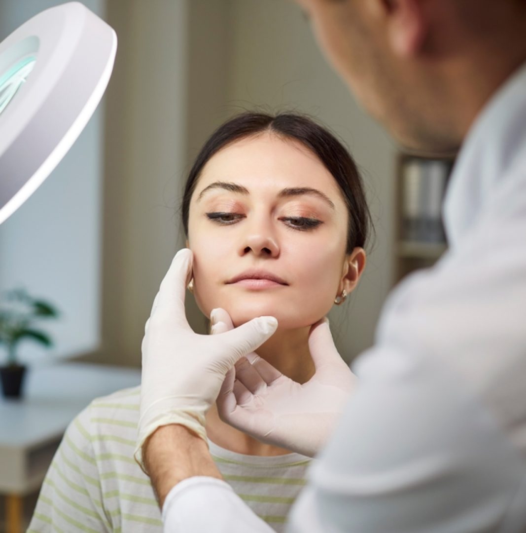 Unrecognizable,Dermatologist,Examining,Patient,Face,,Directing,Lamp,For,Good,Vision,