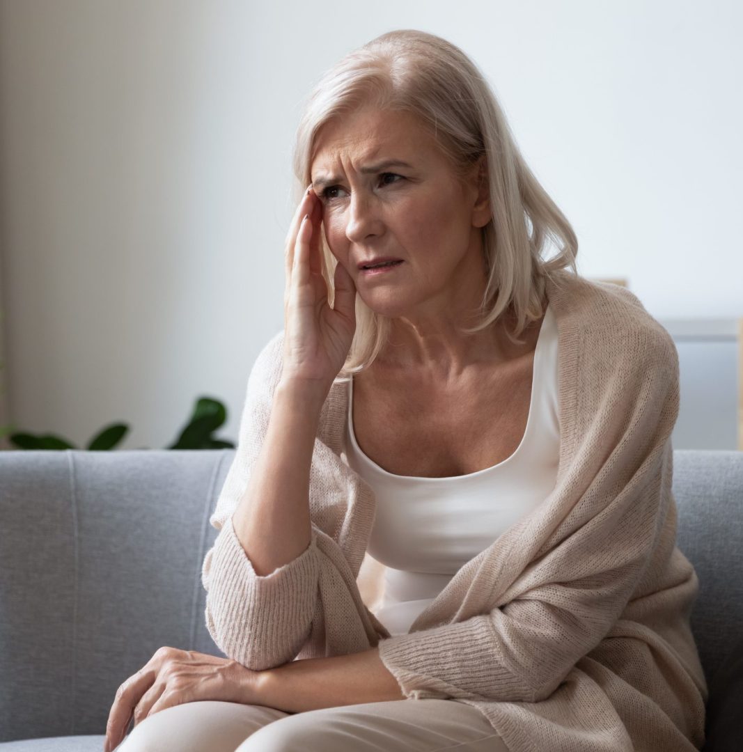 Unhappy,Mature,Woman,Touching,Head,,Feeling,Strong,Headache,,Sitting,On
