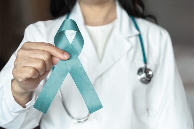 Teal,Awareness,Ribbon,In,Female,Doctor's,Hand,,Bow,Color,For