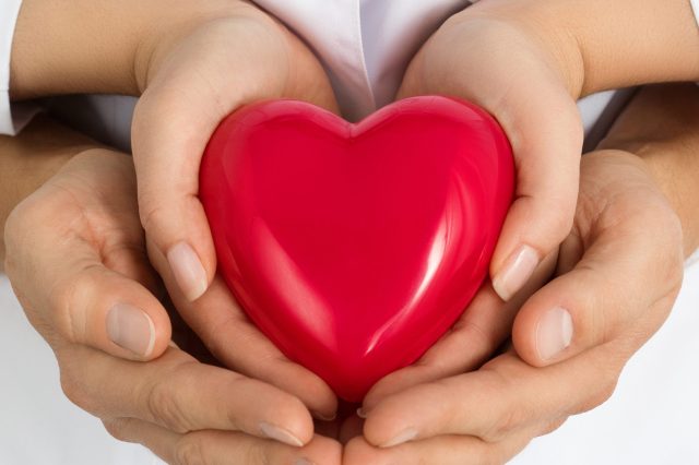 Woman,And,Man,Holding,Red,Heart,Together,In,Their,Hands.