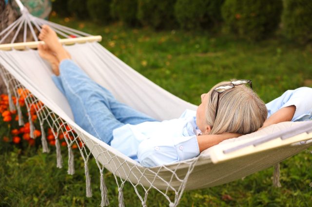 Senior,Woman,Resting,In,Comfortable,Hammock,Outdoors